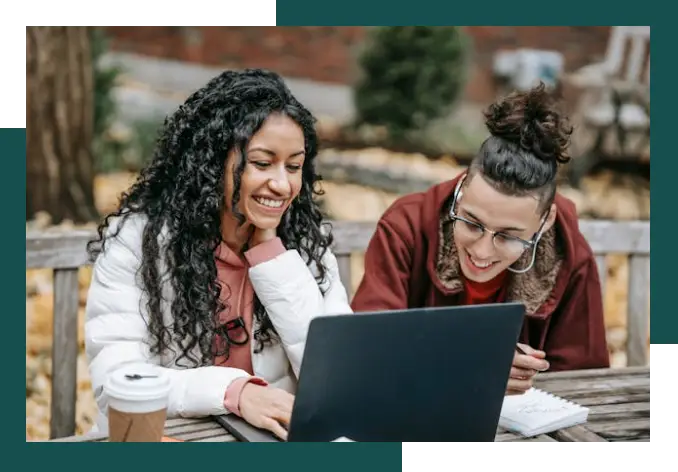 two womans looking in lap top, smiling